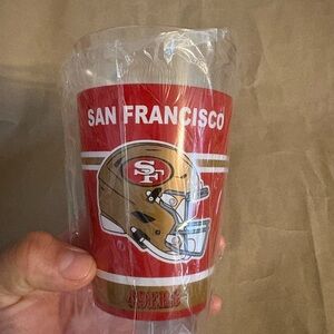 San Francisco 49ers cup featuring a red and gold design with team logo.